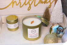 Load image into Gallery viewer, Matte gold 12 oz candle with a wooden wick in the best selling scent of the holiday season, Christmas Hearth!
